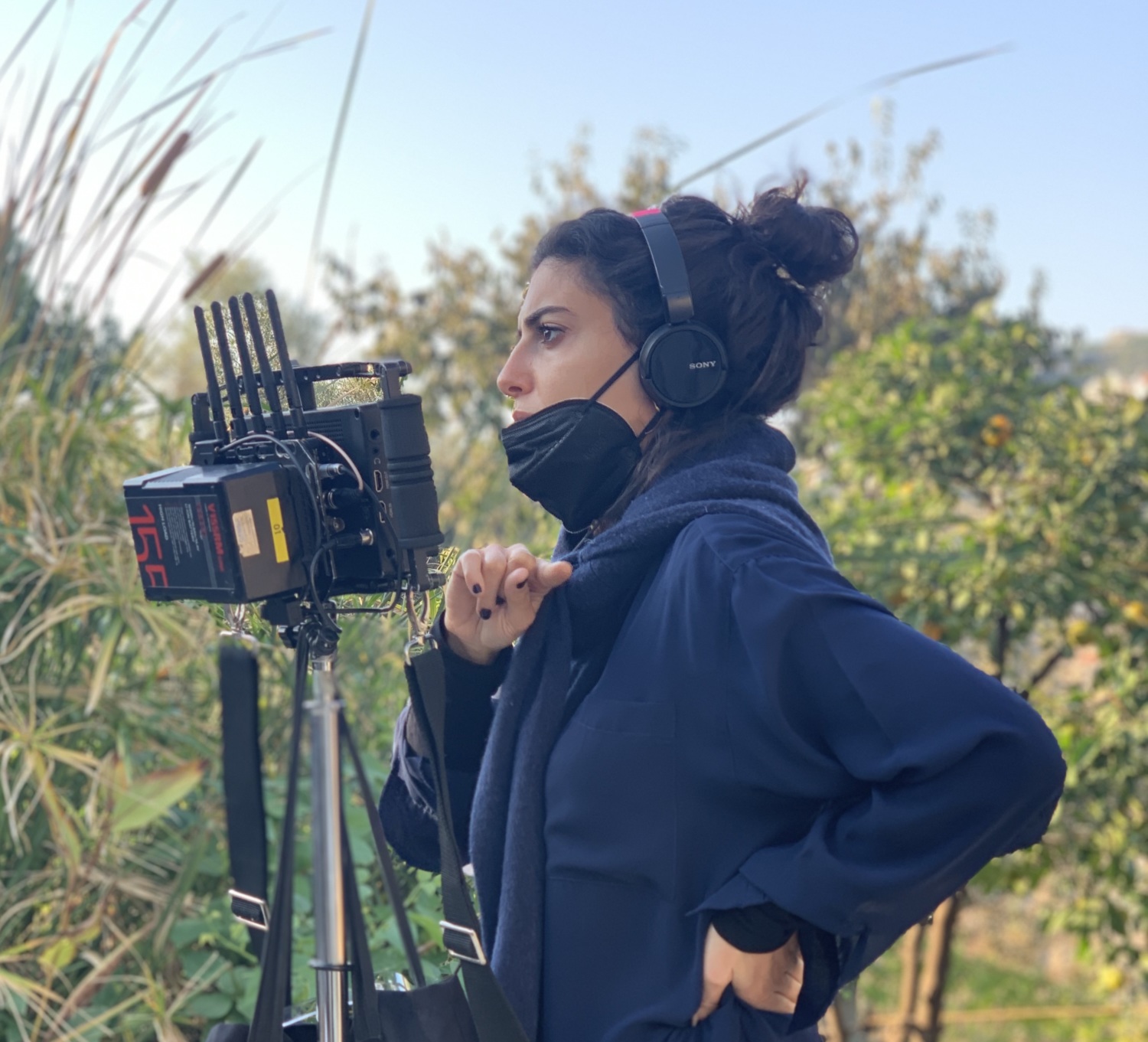 Director Mounia Akl on set looking at a monitor