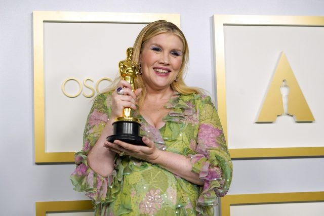 Emerald Fennell holding her Oscar statue