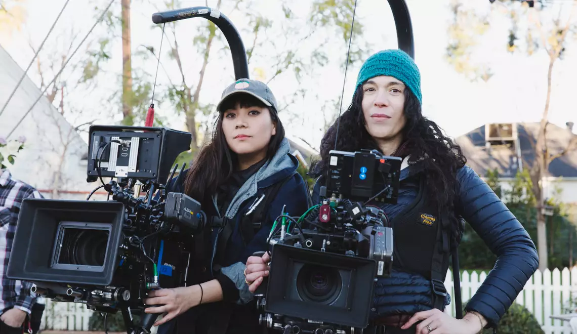 Two cinematographers wearing easy rigs attached to cameras