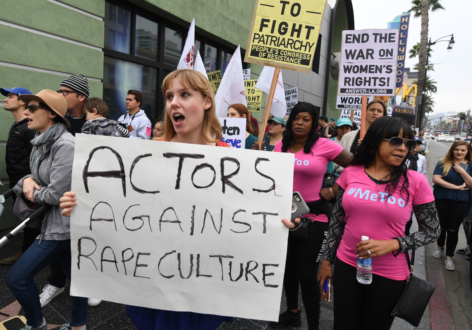 Woman at a protest holding a sign that reads 'actors against rape culture'